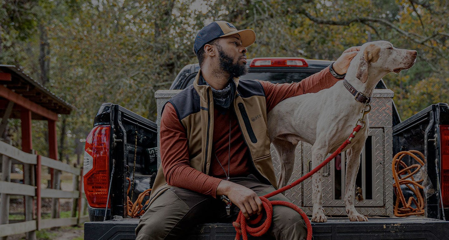 Durrell Smith and his dog sitting together on a truck bed, enjoying a peaceful moment.